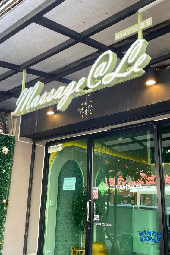 The entrance of Massage @ Le in Bangkok with its illuminated sign and modern storefront welcoming visitors. Original photo by Ariana of WinterExpat.