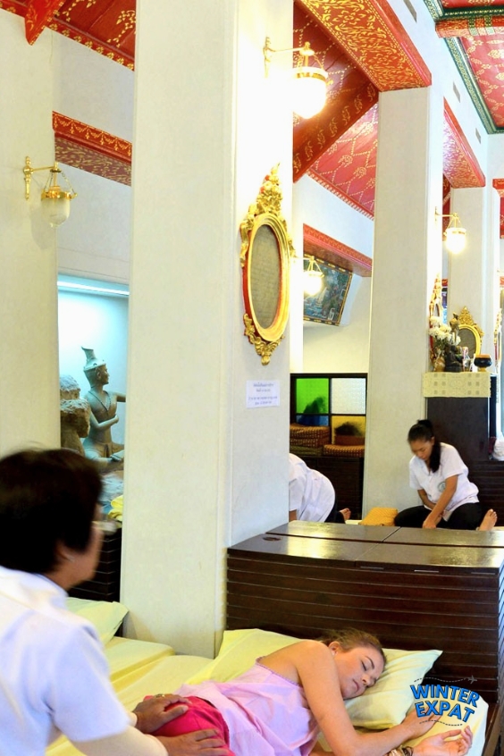 A therapist performs a traditional Thai massage on a guest inside the historic Wat Pho Thai Traditional Massage School in Bangkok. Original photo by Ariana of WinterExpat.