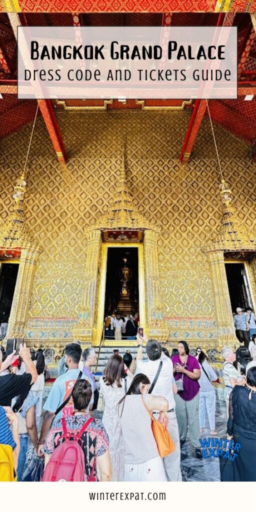 A crowd of tourists looking at and taking photos of a giant, golden temple wall at the Grand Palace in Bangkok. A large open doorway reveals a glimpse inside the building, and a text overlay at the top reads "BANGKOK GRAND PALACE DRESS CODE AND TICKETS GUIDE." Original photo by Ariana of WinterExpat.